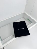 Maglietta nera minimalista in vetrina moderna, elegante e raffinata, ideale per uno stile sofisticato.