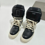 Sneakers alte nere e crema in pelle, con suola spessa e design urbano moderno e versatile.