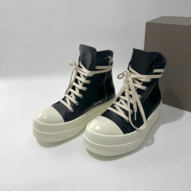 Sneakers alte nere con suola bianca, lacci crema e stile urbano moderno e alla moda.