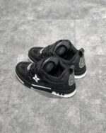 Sneakers nere moderne con dettagli bianchi, logo riflettente e suola antiscivolo, stile urbano e versatile.