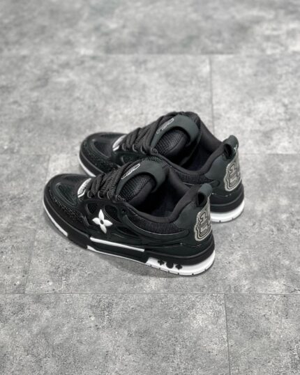 Sneakers nere moderne con dettagli bianchi, logo riflettente e suola antiscivolo, stile urbano e versatile.