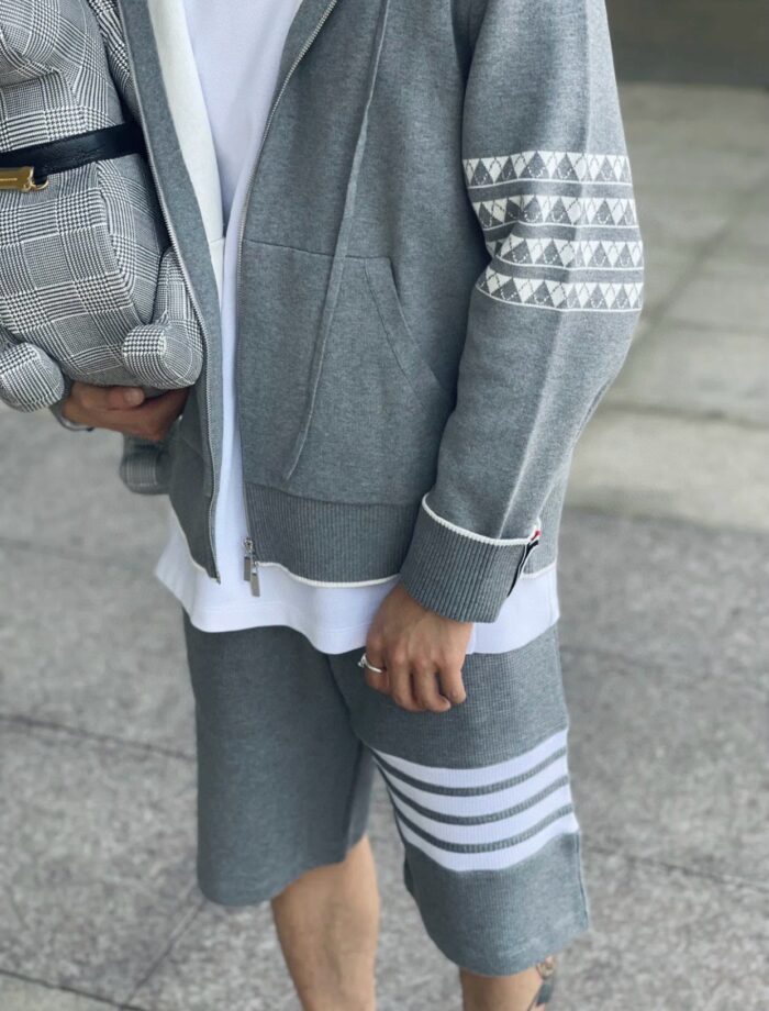 Stilato casual sportivo in grigio con zaino moderno e outfit elegante e comodo.