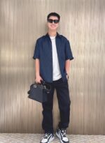 Stilato urbano casual chic con cappello, sneakers e borsa elegante ad ambientazione moderna dorata.