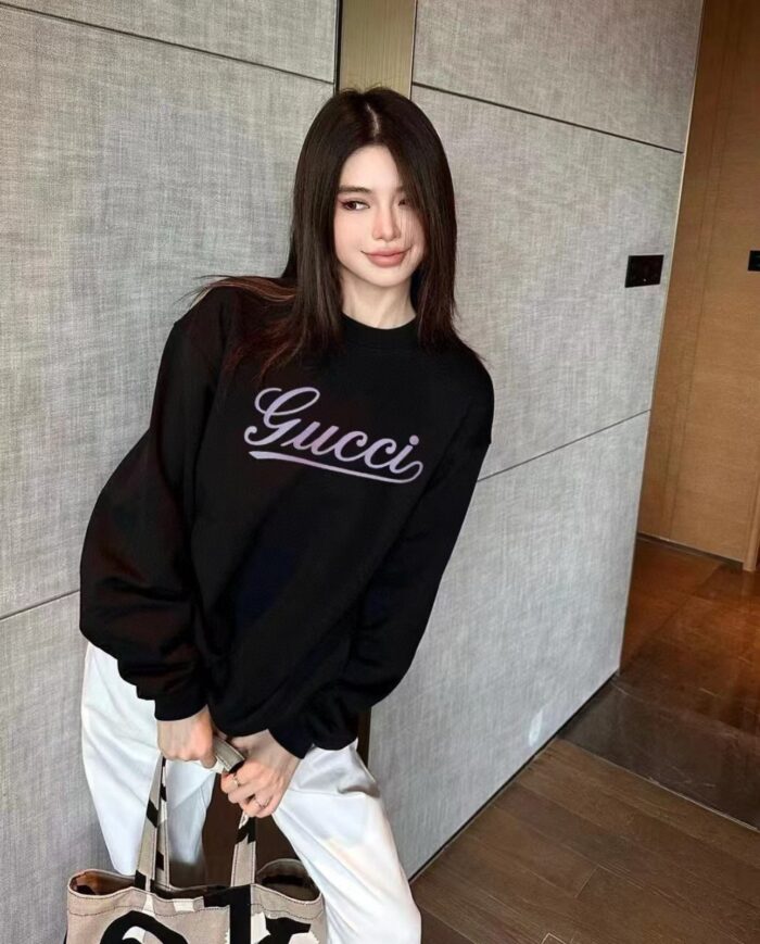 Donna giovane con logo Gucci e borsa di lusso in ambiente moderno e elegante.
