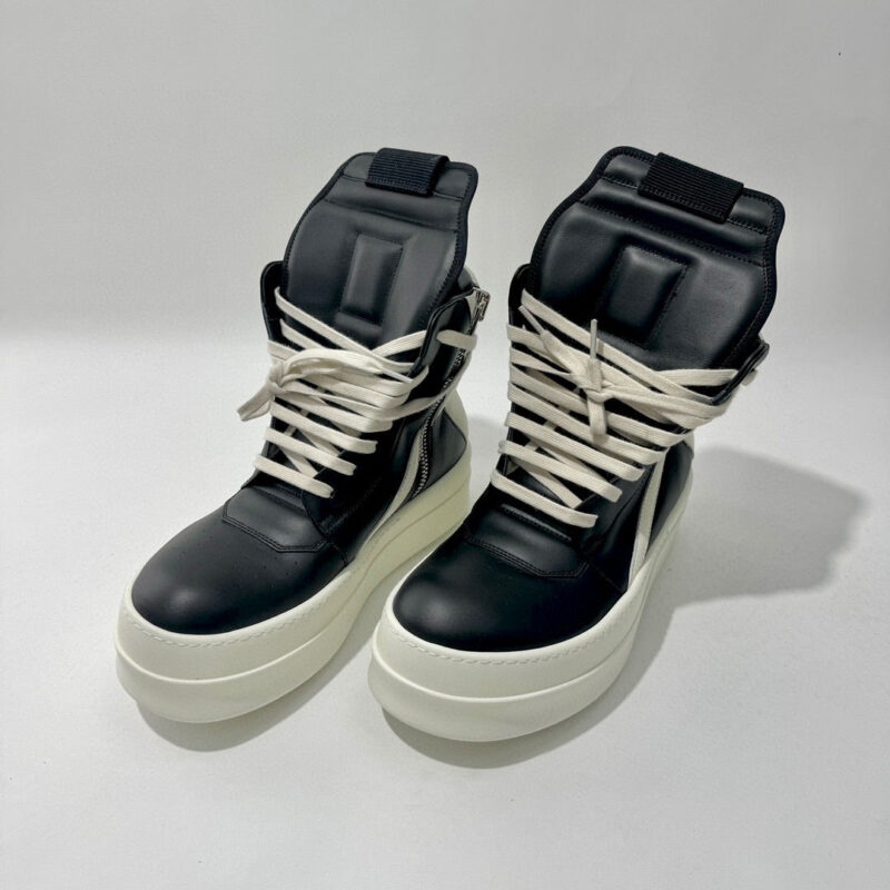 Sneakers alte nere con suola bianca spessa, stile urbano contemporaneo e comfort moderno.