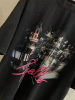 Maglietta nera con grafica urbana night, scritta Spall rosa e scene cittadine moderne e classiche.
