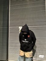 Ragazzo con hoodie Balenciaga in ambientazione urbana moderna e minimalista.