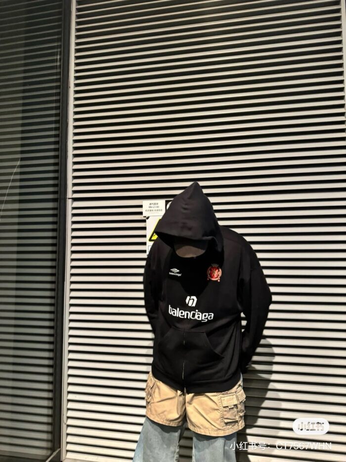 Ragazzo con hoodie Balenciaga in ambientazione urbana moderna e minimalista.