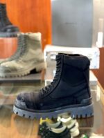 Stivali outdoor e urbani resistenti in materiali robusti, display elegante su sfondo in legno.