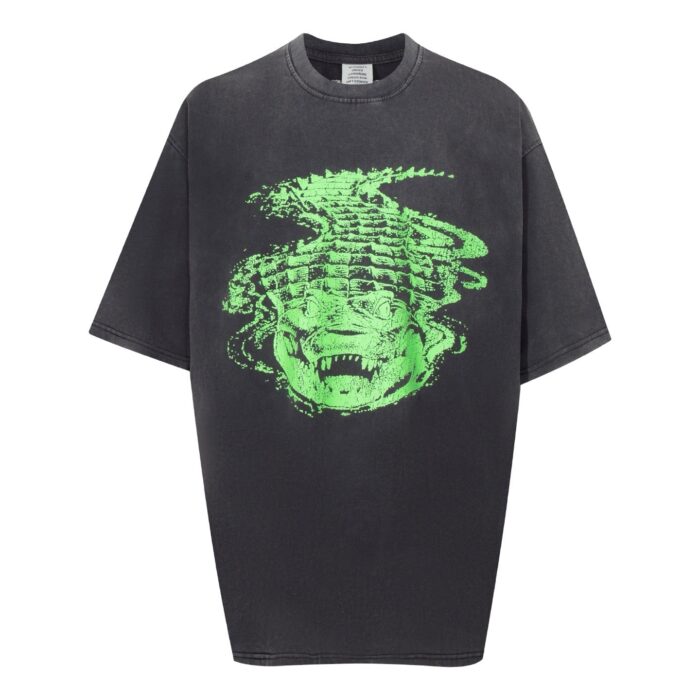 T-shirt oversize grigia con grafica di volto distorto verde, stile streetwear moderno e casual.