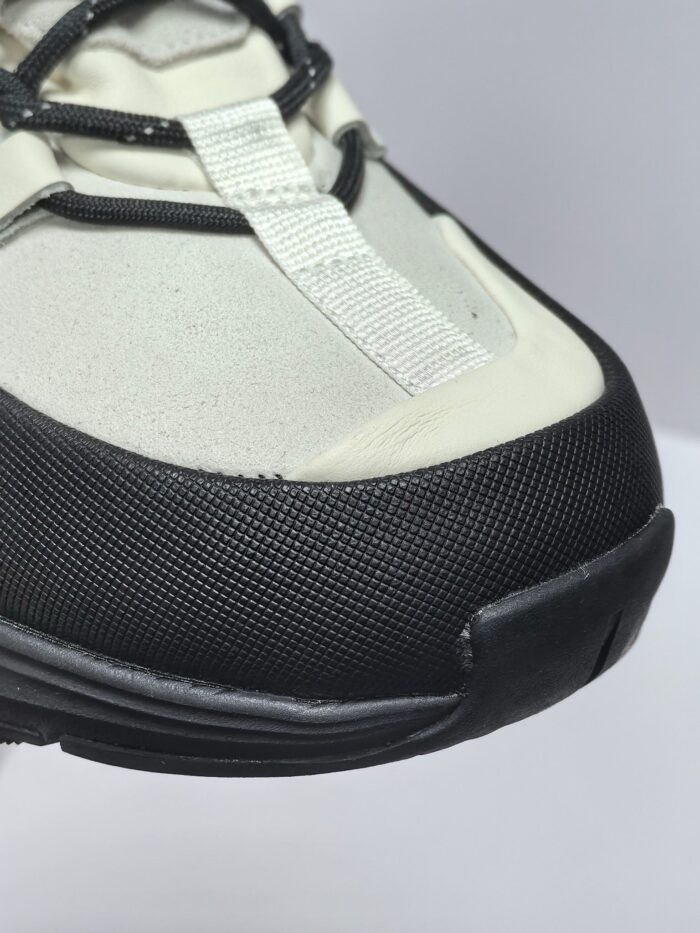 Sneaker moderna neutra con dettagli neri, suola flessibile e design urbano versatile.