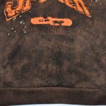 Felpa casual con grafica SPAR arancione, texture rugged e doppio taschino centrale.