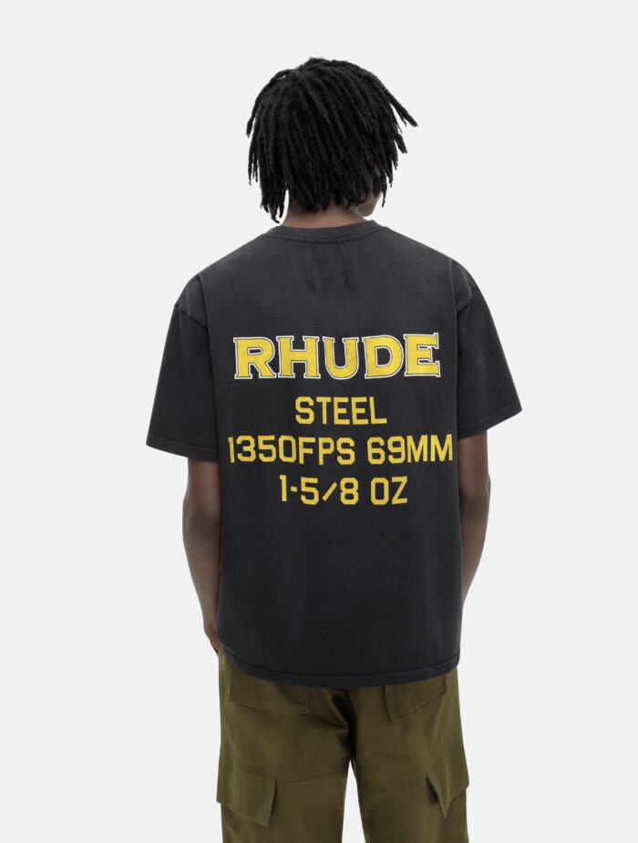 Stile streetwear con t-shirt grafica gialla, dreadlocks e pantaloni oliva, look moderno e sicuro.