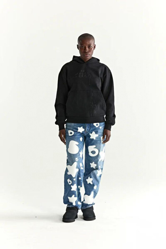 Stile urbano giovanile con hoodie nero e jeans decorati con motivi giocosi e vivaci