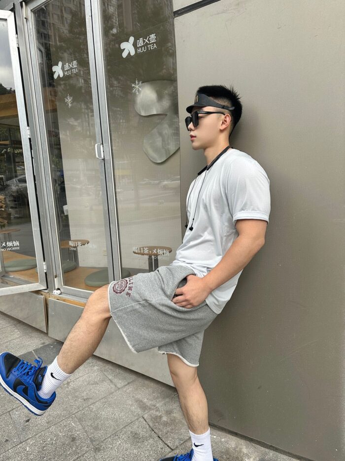 Giovane uomo casual con sneakers blu in unambientazione urbana moderna e rilassata.
