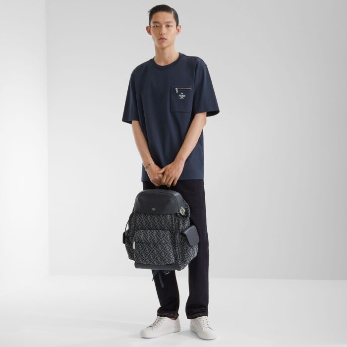 Giovane uomo in stile casual urbano con zaino moderno e sneakers bianche.