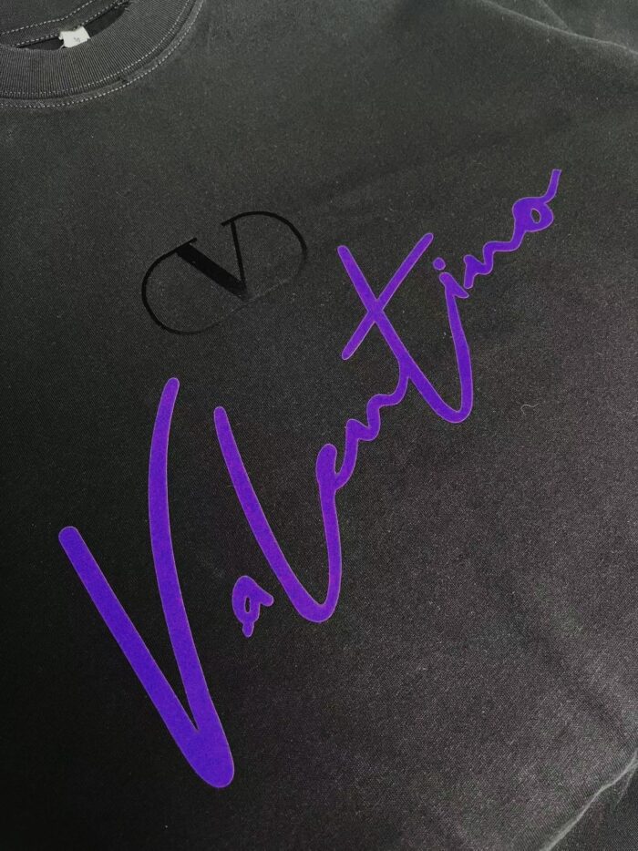 Maglietta nera Valentino con logo viola elegante e dettagli minimalisti, stile fashion streetwear.