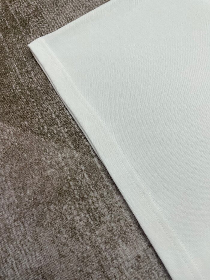 Tessuti eleganti in cotone bianco e velours marrone per arredamento e moda.