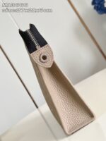 Borsa elegante beige con forma geometrica, dettaglio a vite e zip nero, stile moderno e pratico.