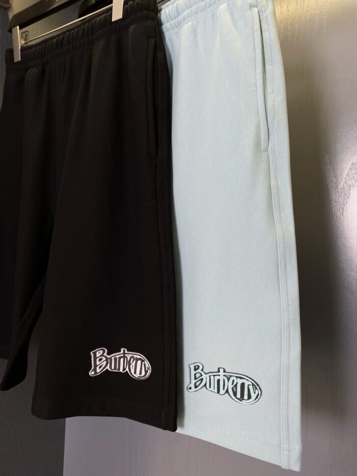 Shorts sportivi eleganti nero e azzurro con logo ricamato, stile casual e raffinato.