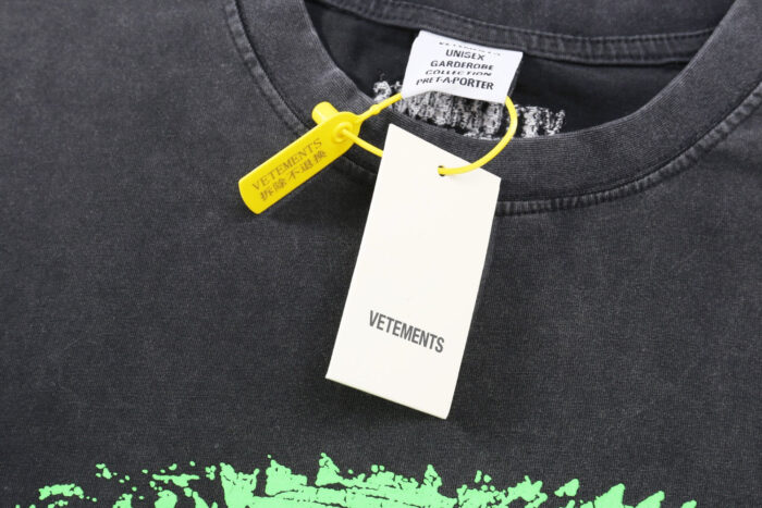 T-shirt nero Vetements distressed con etichetta bianca e security tag giallo.