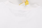 Maglietta bianca VETEMENTS con logo embossato e tag security gialla.