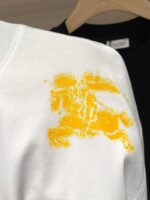 Maglietta bianca con design astratto giallo, stile moderno e fashion, sfondo nero sfocato.