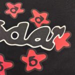 Maglietta nera con logo radar bianco e stelle rosse dinamiche, stile giovane e vivace.