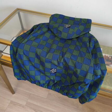 Giacca a quadri verde e blu con cappuccio, stile streetwear, su tavolo di vetro.
