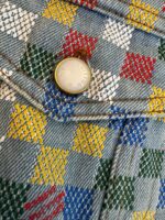 Jeans patchwork colorati in denim con bottone dorato, stile casual e fashion.