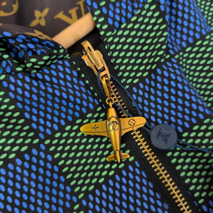 Giacchetto colorato con zip oro e charm aeroplanino, stile moderno e design innovativo.