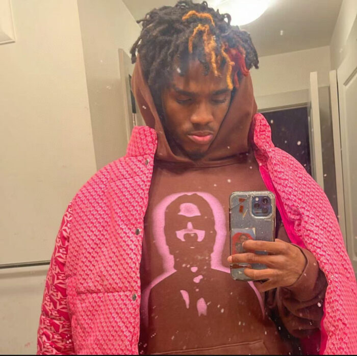 Ragazzo con dreadlocks e stile urbano prende un selfie in bagno.