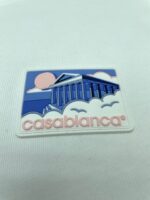 Logo Casablanca con tempio classico, cielo colorato e scritta rosa.
