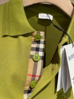 Polo verde con colletto Burberry a quadri e bottoni coordinati, stile moderno e di tendenza.