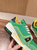 Sneaker sportiva verde con dettagli gialli, design moderno e suola antiscivolo.
