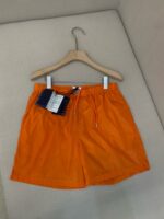Shorts da spiaggia arancioni leggeri, perfetti per lestate e il mare.