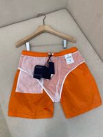 Costume da spiaggia arancione con dettaglio pink e bianco, stile estivo e alla moda.