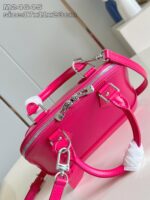 Borsa rosa brillante con tracolla, manico corto e pom-pom trendy, perfetta per look giovanili.