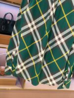 Camicia verde con quadri a linee bianche e gialle, stile casual e vestibilità rilassata.