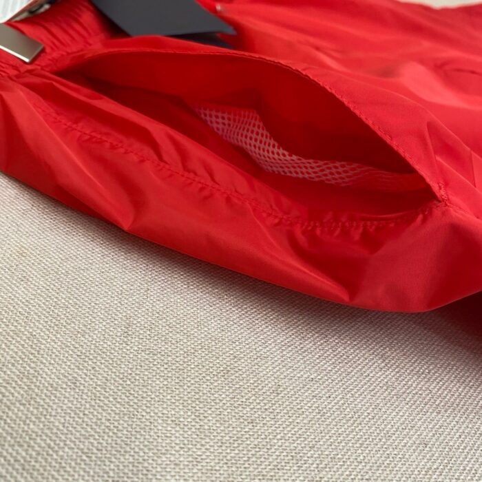 Pantaloncini sportivi rossi con tasche a rete ventilate e cinturino elastico.