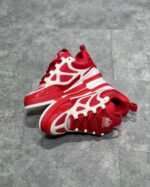 Sneakers da basket rosse con dettagli scolpiti, inserti traspiranti e design moderno sportivo.
