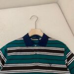 Maglietta polo a righe colorate con colletto blu, ideale per stile casual e raffinato.