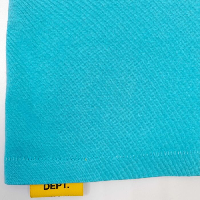 T-shirt casual turquoise con etichetta gialla, dettaglio della cucitura e stile estivo, qualità.