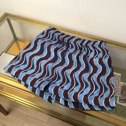 Pantaloncini estivi a onde colorate su tavolo di vetro, stile casual e vivace.