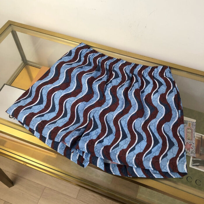 Pantaloncini estivi a onde colorate su tavolo di vetro, stile casual e vivace.