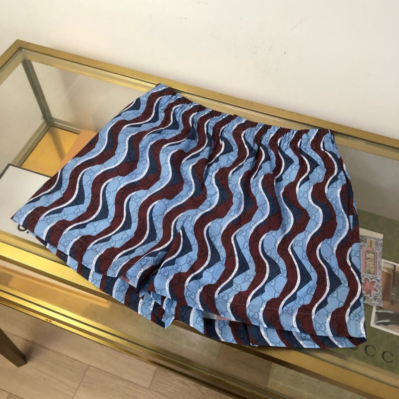 Pantaloncini estivi a onde colorate su tavolo di vetro, stile casual e vivace.