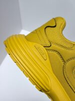 Sneaker gialla moderna con suola antiscivolo, logo discreto e design elegante.