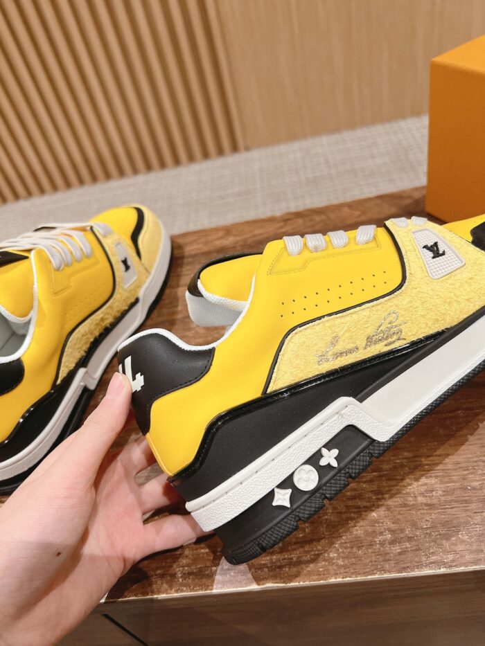 Sneakers gialle alla moda con dettagli neri, design moderno e suola robusta.