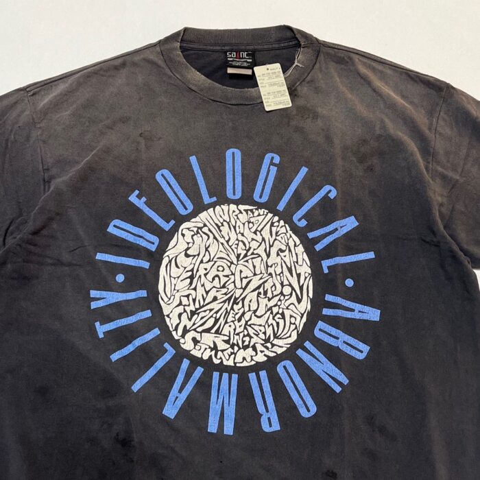 Maglietta nera con grafica astratta e testo circolare blu, stile vintage e design moderno.