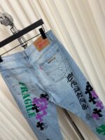 Jeans vintage con grafica colorata, fiori, scritta FRAGILE e dettagli edgy streetwear.